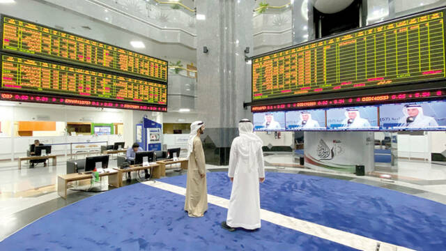 متداولان يتابعان أداء الأسهم بسوق أبوظبي للأوراق المالية - أرشيفية