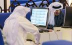 متعاملون يتابعون أسعار الأسهم بقاعة سوق دبي المالي