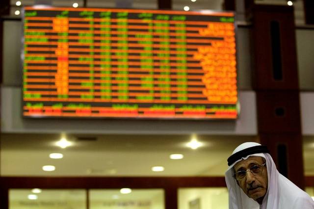 متعامل يتابع أسعار الأسهم ببورصة دبي المالي