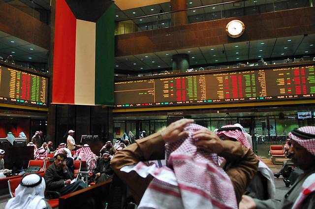متعاملون يتابعون الأسعار بقاعة سوق الكويت المالي، الصورة من رويترز أريبيان آي