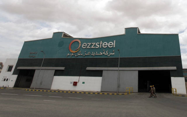 عاملان أمام شركة حديد عز - الصورة من رويترز أريبيان أي