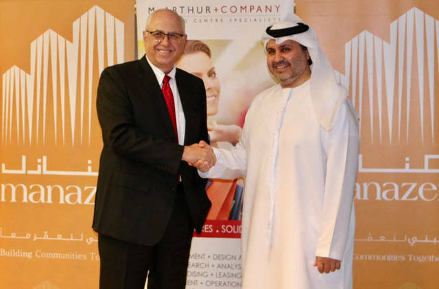 ممثل شركة منازل العقارية وماك أرثر+ كومباني أثناء توقيع الاتفاقية - الصورة من بيان الشركة