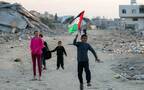 أطفال في غزة يلوحون بعلم بلادهم