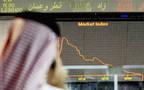 مستثمر أمام شاشة تداول ببورصة قطر